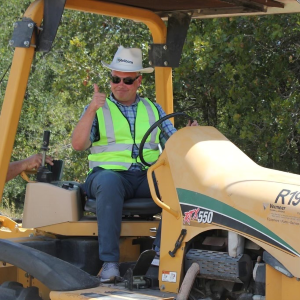 KG Worker on a tractor with a thumbs up